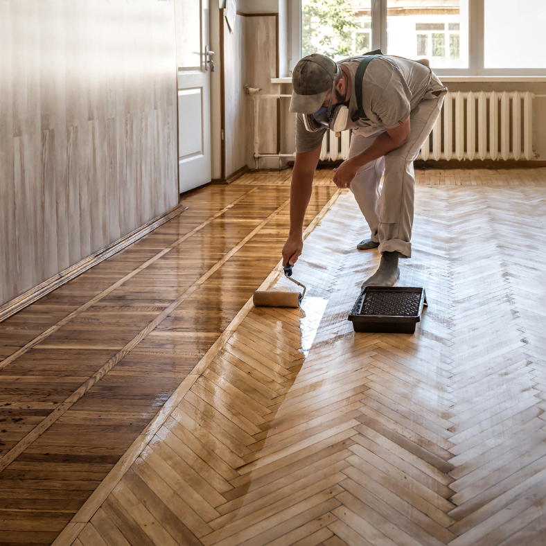 homeowner-applying-varnish-on-wooden-floor