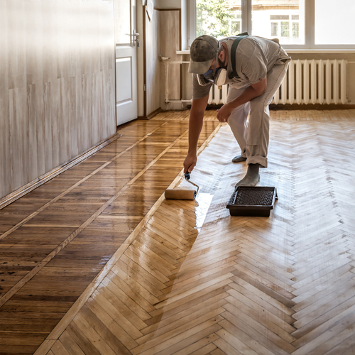 homeowner-applying-varnish-on-wooden-floor